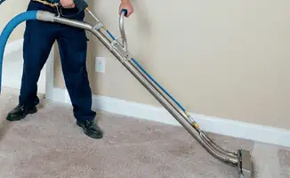 Professional operating a liquid removal machine on a carpeted floor in Pasadena, CA
